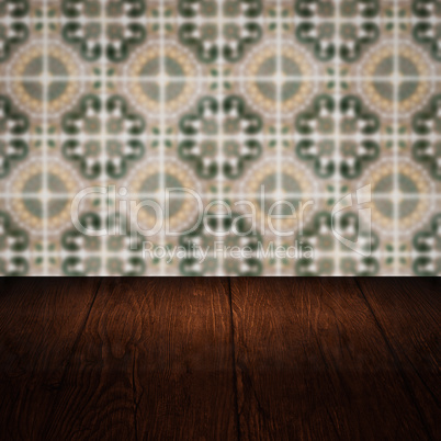 Wood table top and blur vintage ceramic tile pattern wall