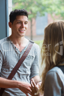 Smiling male student talking to a friend