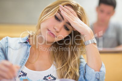 Attractive female student thinking during exam