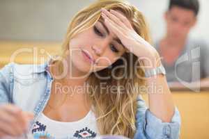Attractive female student thinking during exam