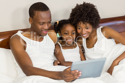 Happy family lying in bed together