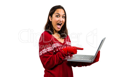 Shocked woman using laptop while wearing warm clothing