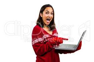 Shocked woman using laptop while wearing warm clothing