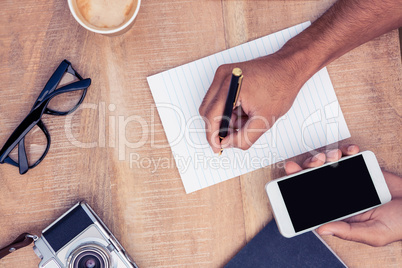 Cropped image of businessman writing on notepad