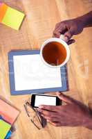 Businessman having coffee while using technologies