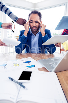 Stressful businessman with head in hands at creative office