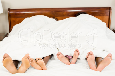 Parents and kids feet at the end of the bed