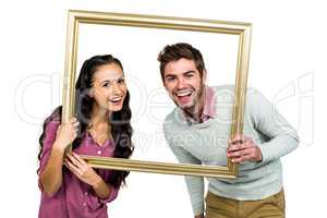 Portrait of happy couple holding picture frame
