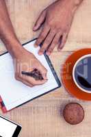 Overhead view of man writing on diary