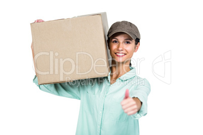 Cheerful delivery woman holding pack showing thumb up