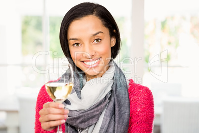 Smiling brunette holding glass of white wine