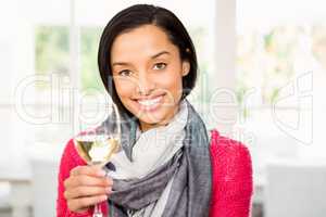 Smiling brunette holding glass of white wine
