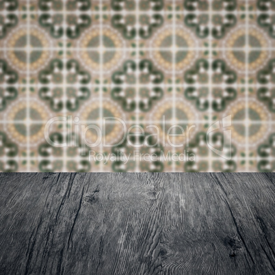 Wood table top and blur vintage ceramic tile pattern wall