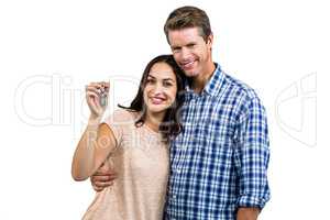 Portrait of happy couple embracing while holding keys