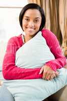 Smiling brunette holding pillow