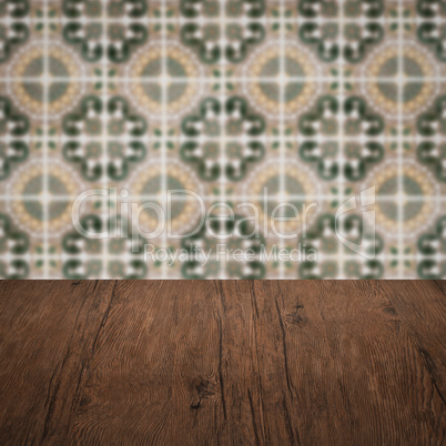 Wood table top and blur vintage ceramic tile pattern wall