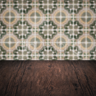 Wood table top and blur vintage ceramic tile pattern wall