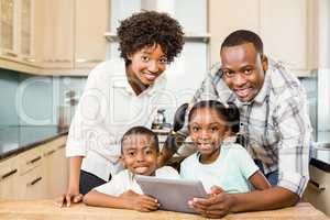 Happy family using tablet in kitchen