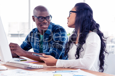 Businessman discussing with businesswoman at desk
