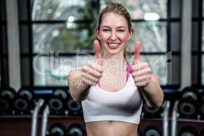 Smiling fit woman showing thumbs up