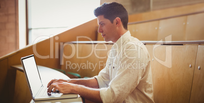 Concentrated male student using laptop