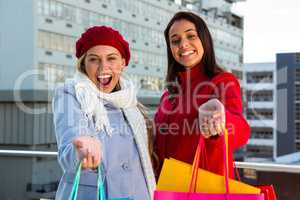 Two girls showing their shopping bags