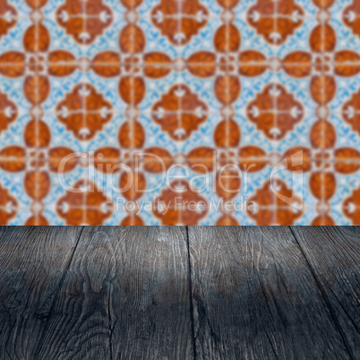 Wood table top and blur vintage ceramic tile pattern wall