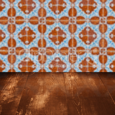 Wood table top and blur vintage ceramic tile pattern wall