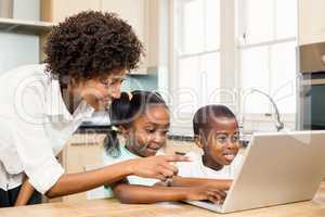 Happy family using laptop in the kitchen