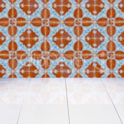 Wood table top and blur vintage ceramic tile pattern wall