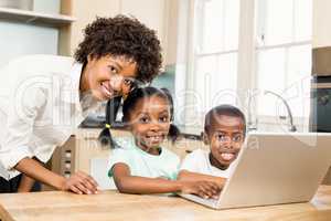 Happy family using laptop in the kitchen