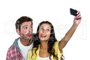 Couple sticking out tongue while taking selfie