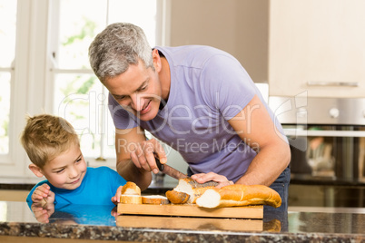 Happy father slicing bread