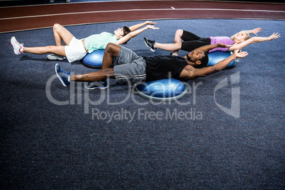 Fit people doing exercise with bosu ball