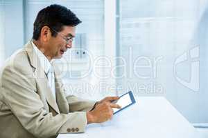 Smiling asian businessman using tablet