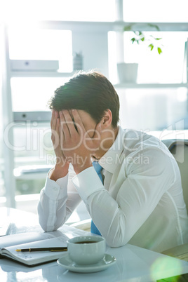 Tired asian businessman working at his desk