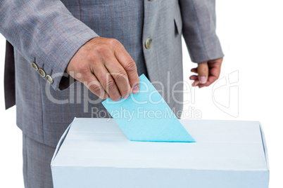 Businessman putting ballot in vote box