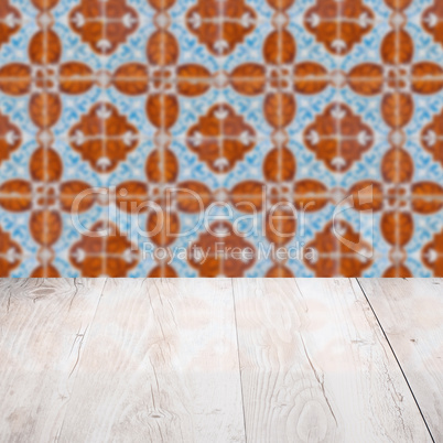 Wood table top and blur vintage ceramic tile pattern wall