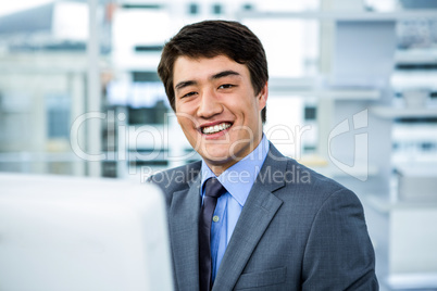 Smiling asian businessman is working