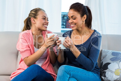 Friends having tea on sofa