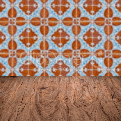 Wood table top and blur vintage ceramic tile pattern wall