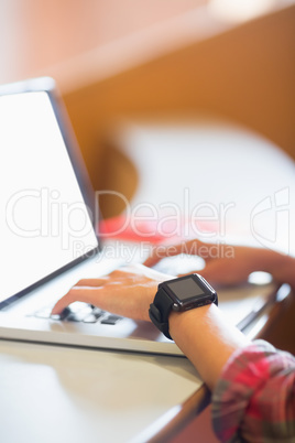 Smiling female student using laptop