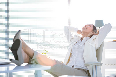 Businesswoman relaxing with legs on desk