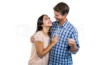 Happy couple embracing while holding keys