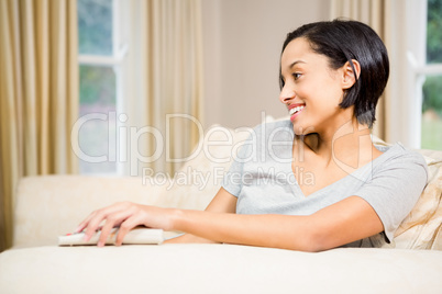 Smiling brunette using remote