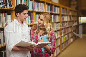 College students reading book together