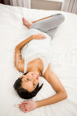 Smiling brunette lying on the bed