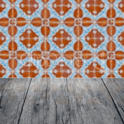 Wood table top and blur vintage ceramic tile pattern wall Wood table top and blur vintage ceramic tile pattern wall