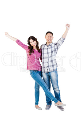 Happy young couple with hands raised