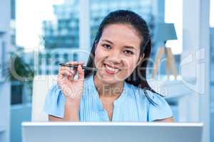 Smiling young businesswoman sitting at her desk